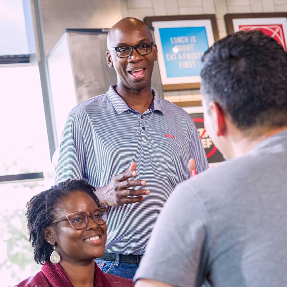 three Wendy's employees talking at work