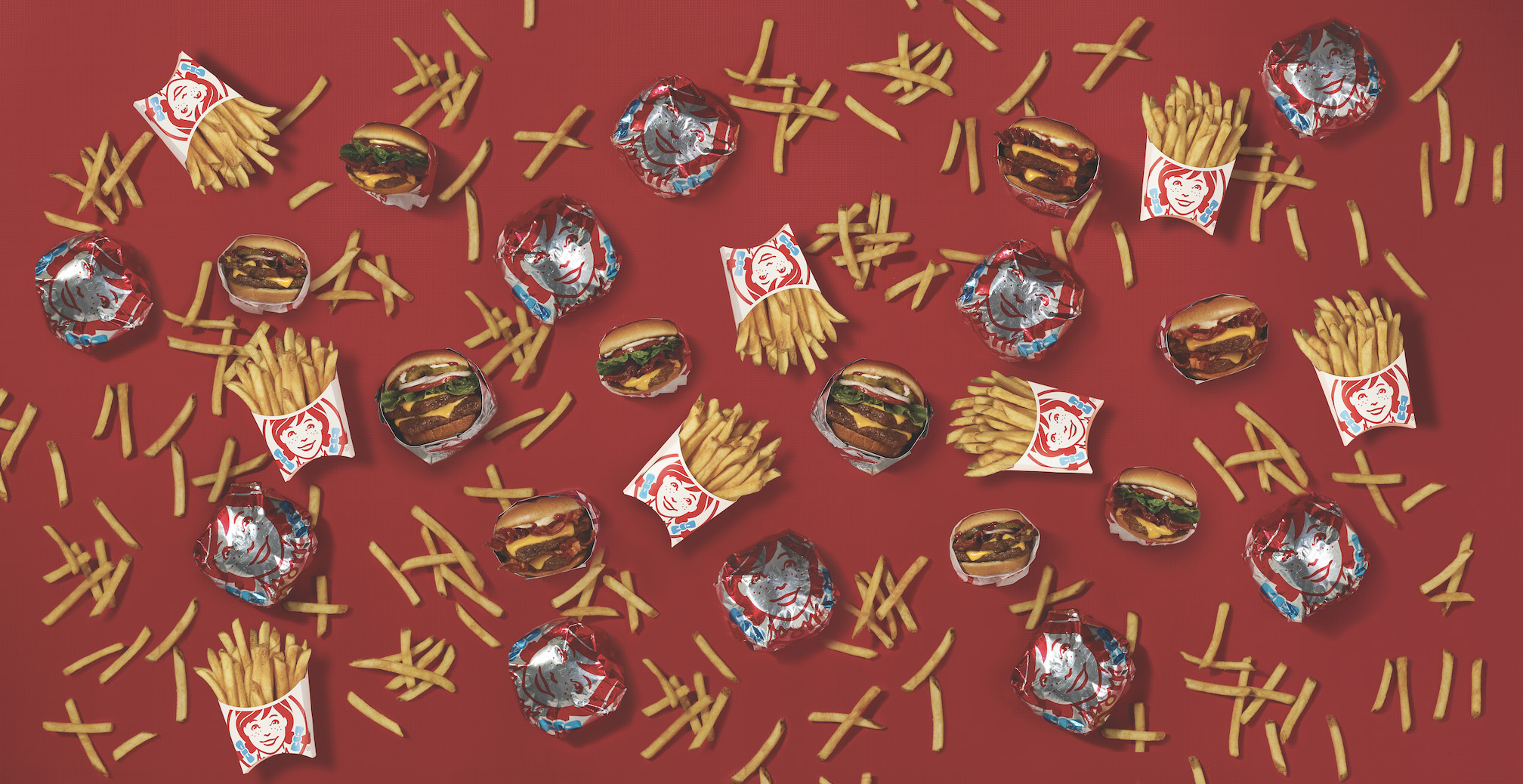 Fries, Wrapped Sandwiches on Red Background Behind Text
