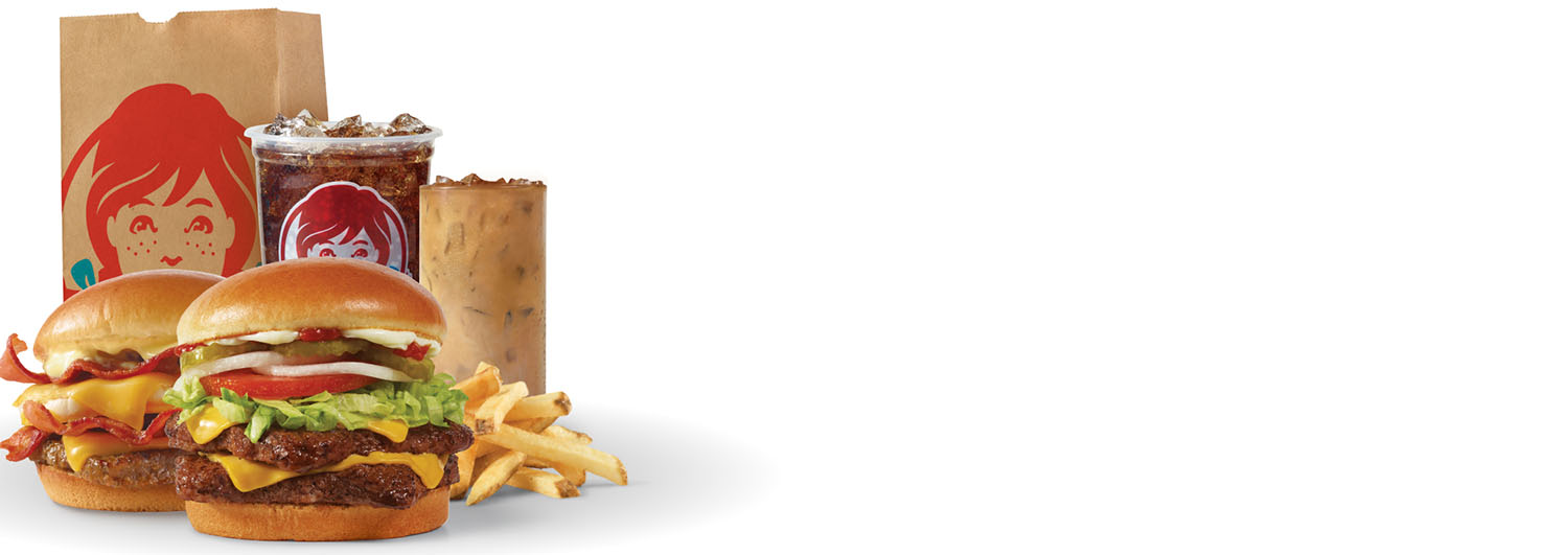 Get Wendy's Delivered: Breakfast Baconator® combo with seasoned potatoes and Frosty-ccino®, and Dave's Double® combo with fries and soft drink next to a Wendy's bag