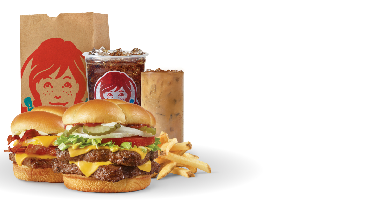 Get Wendy's Delivered: Breakfast Baconator® combo with seasoned potatoes and Frosty-ccino®, and Dave's Double® combo with fries and soft drink next to a Wendy's bag
