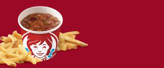 Small chili with fries on dark red background