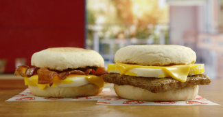 Two Wendy's English Muffin Sandwiches featuring Bacon or Sausage stacked with egg and cheese